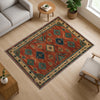 Aztec-inspired chenille rug with oriental influence, rust red background, blue and cream tribal diamond motifs, washable non-slip backing, perfect for boho and rustic decor.
